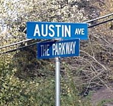The new, blue, and larger street sign for Austin Avenue and The Parkway